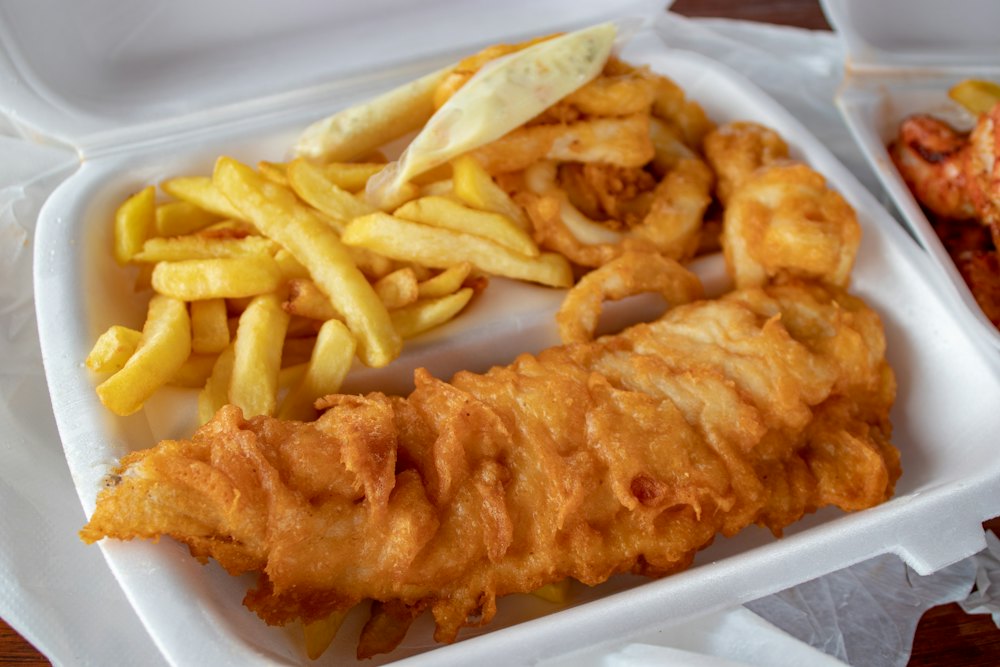 Stock photo of fried fish and fries in a takeout box